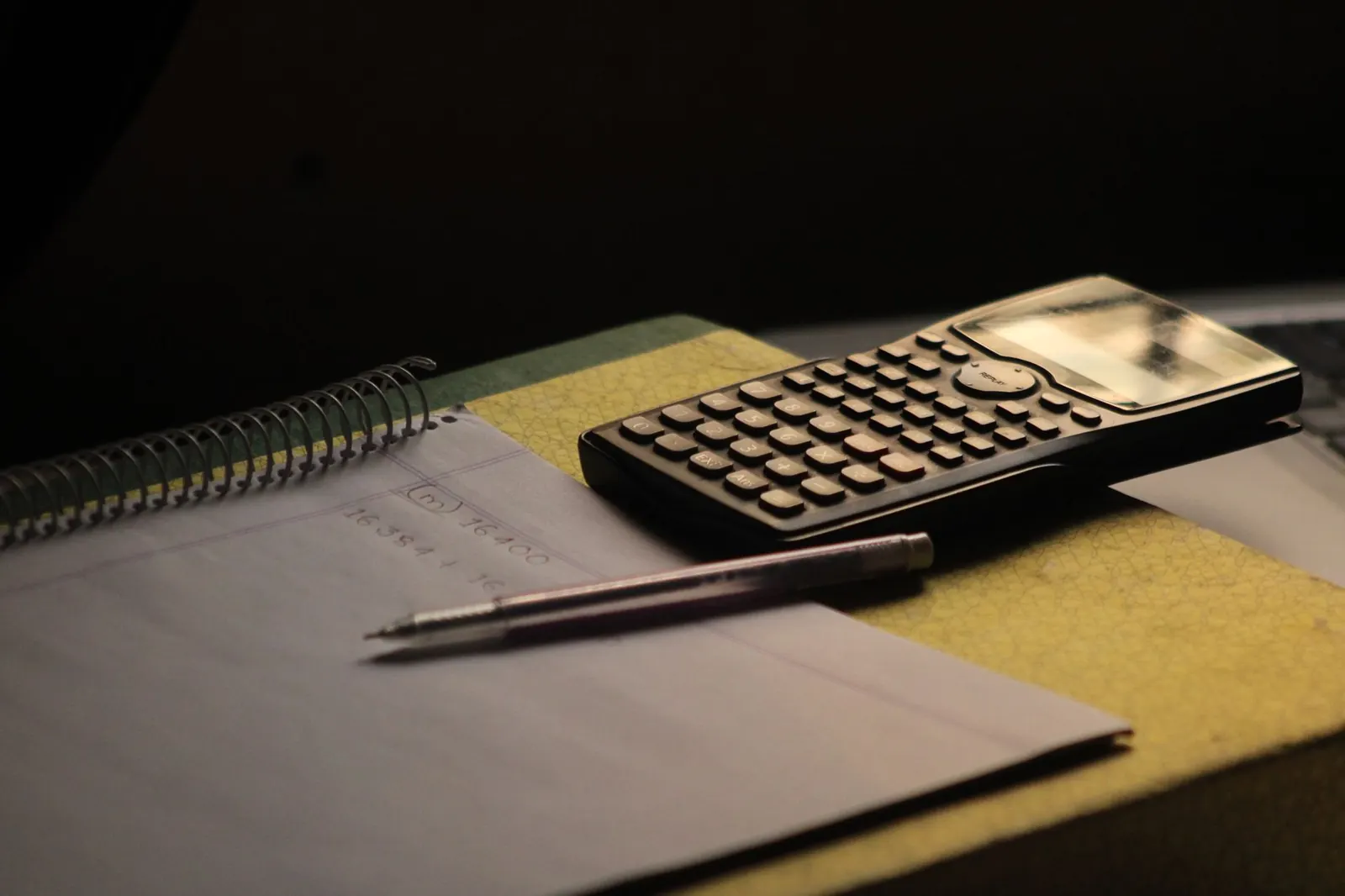 Close-up of a calculator and notebook on a study desk. Ideal for education themes.